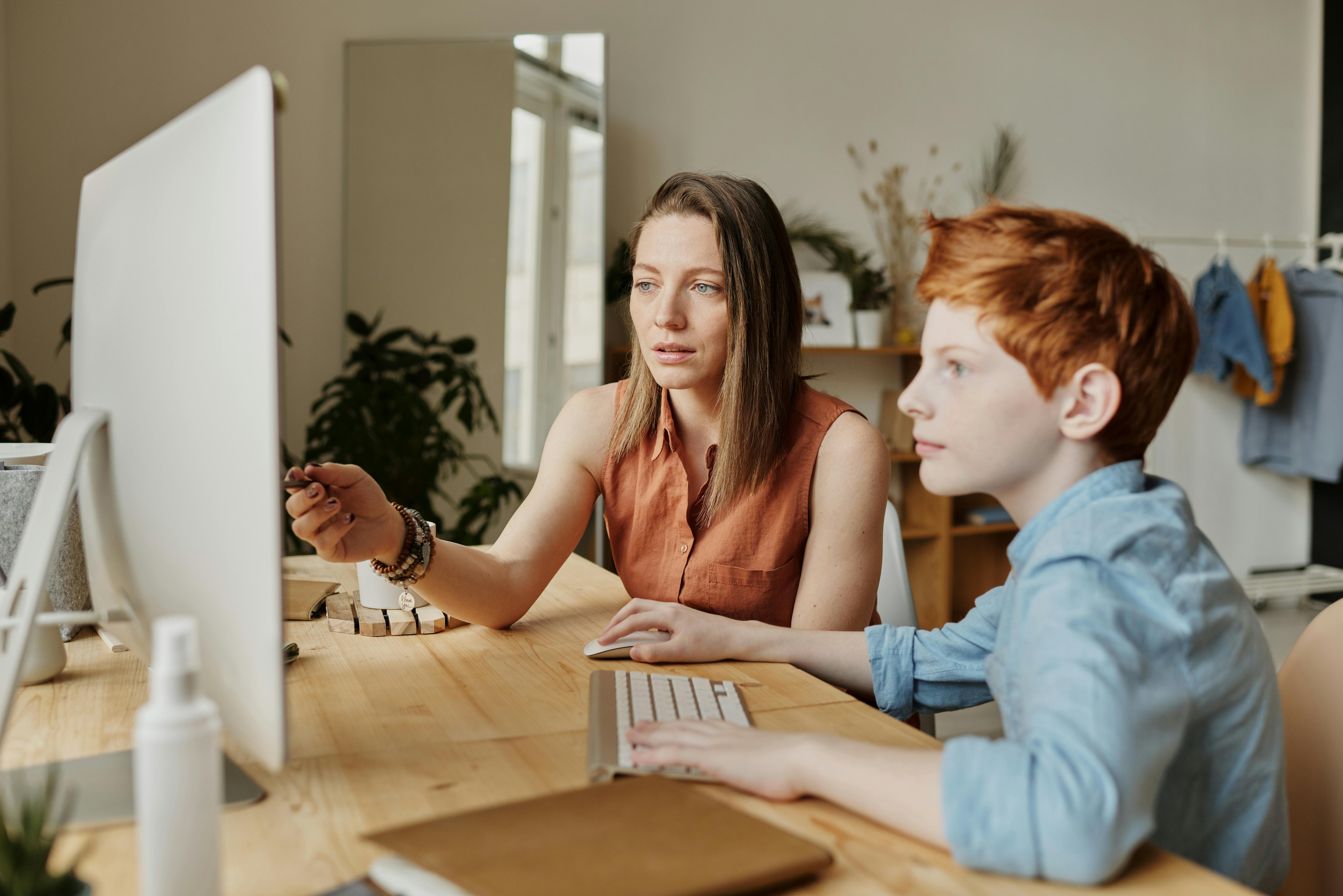 A happy family using a laptop together in their living room.